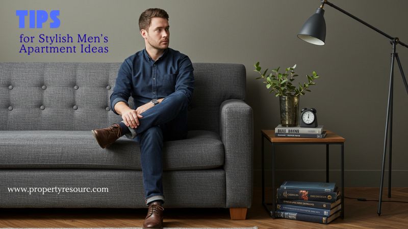 In Men’s Apartment EssentialsMan sitting on grey sofa in stylish apartment with books and floor lamp